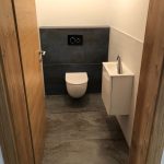 WC mit modernem Waschbecken und Fliesen.