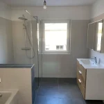 Baezimmer mit Badewanne, Dusche und moderem Waschbecken