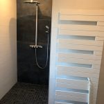 modernes Badezimmer mit offener Dusche und modernem Sprossenheizkörper