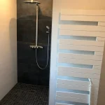 Badezimmer mit Dusche und Sprossenheizkörper